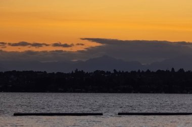 Puget Sound 'un ufkunda puslu turuncu gün batımı