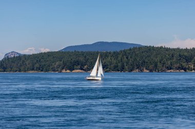 Sparkling Blue Channel 'da Evergreen Hills' in arkasında yelkenli. Yüksek kalite fotoğraf
