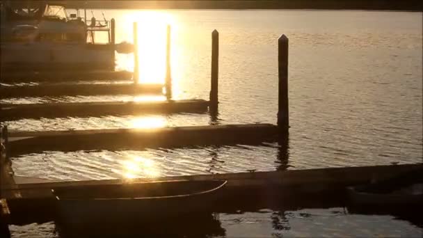 Abendlicht funkelt auf Wasser und dunklem Dock lizenzfreies Stockvideo