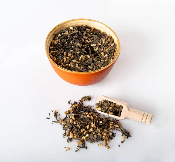 Yeşil çay, yeşil çay, ahşap tabaklarda pirinç ve beyaz arka planda izole edilmiş tahta kaşıklar.