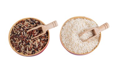 Ahşap tabaklarda siyah beyaz pirinç ve beyaz arka planda izole edilmiş tahta kaşıklar.