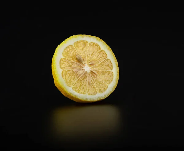 Una Rebanada Limón Fresco Jugoso Sobre Una Superficie Negra Brillante —  Fotos de Stock