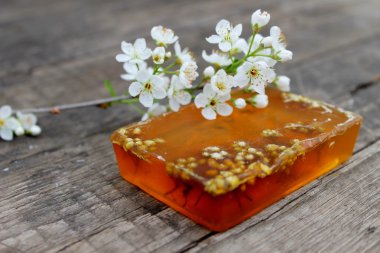 El yapımı Sabun ve ahşap arka plan üzerinde beyaz çiçekler 