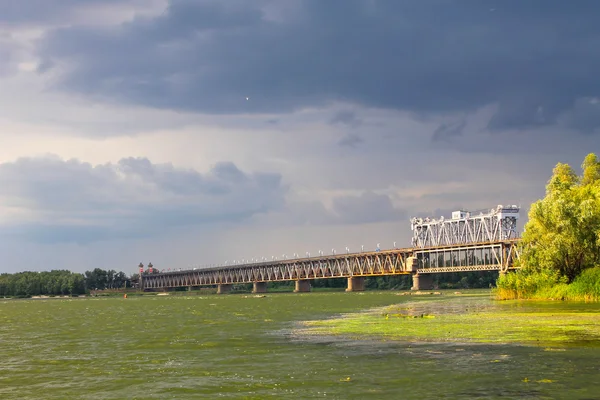 Pont à travers la rivière Dniepr et nuages orageux dans le ciel — Photo