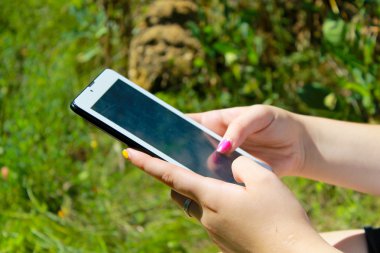 Çim döşeme bir tablet holding kadının eller