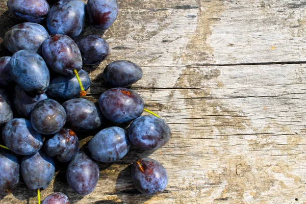 Prugne fresche su fondo rustico in legno — Foto Stock