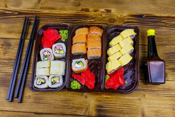 Set Rollos Sushi Cajas Plástico Salsa Soja Palillos Sobre Mesa —  Fotos de Stock