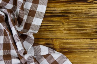 Kahverengi, ahşap mutfak masasında katlanmış peçete. Üst görünüm, alanı kopyala