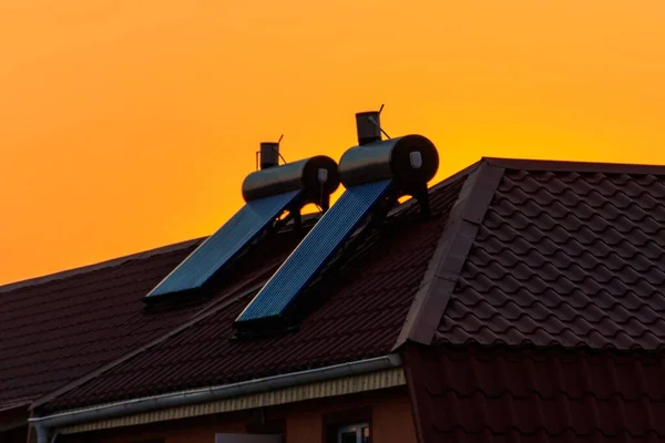 日落时分 住宅屋顶上的太阳能热水器 住房可再生能源 — 图库照片