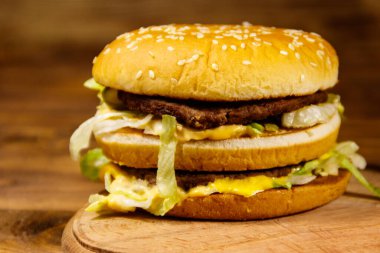 Ahşap masada lezzetli büyük hamburger.