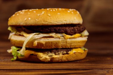 Ahşap masada lezzetli büyük hamburger.