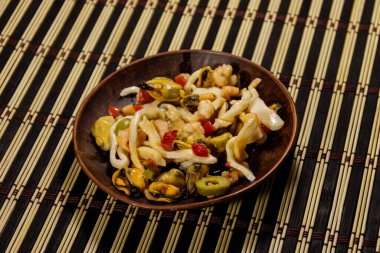 Karides, mürekkep balığı ve bambu hasırlı midye salatası.