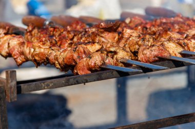 Metal şişte pişen ızgara kebap. Barbeküde kızartılmış et. Geleneksel doğu yemeği, şiş kebap. Kömür ve alevler üzerine ızgara, piknik, sokak yemekleri