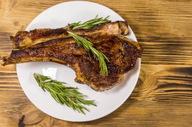 Biberiyeli biftek ve beyaz tabakta ahşap masa.