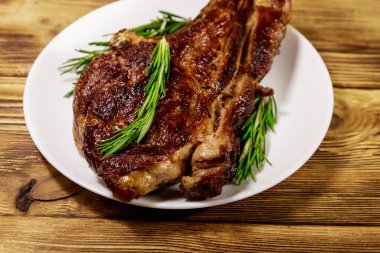 Biberiyeli biftek ve beyaz tabakta ahşap masa.