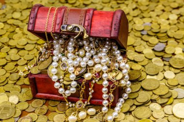 Altın sikke ve mücevherlerle dolu eski bir hazine sandığı.