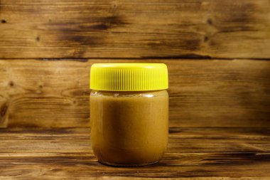 Tahta bir masada fıstık ezmesi kavanozu