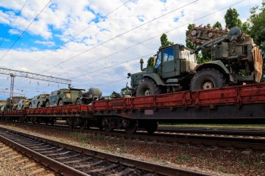 Tren düz vagonlarda askeri araçlar taşıyan kargo treni.