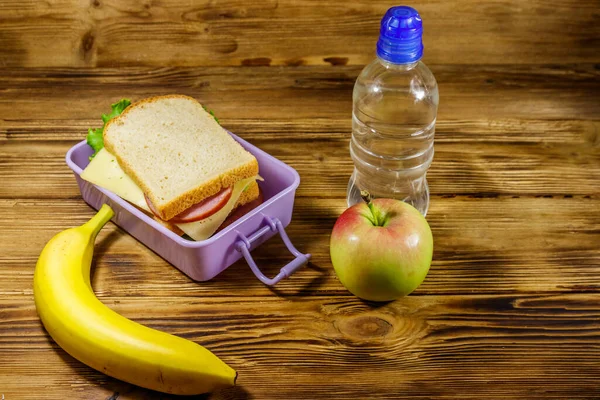 Pranzo Con Panini Bottiglia Acqua Banana Mela Tavolo Legno — Foto Stock