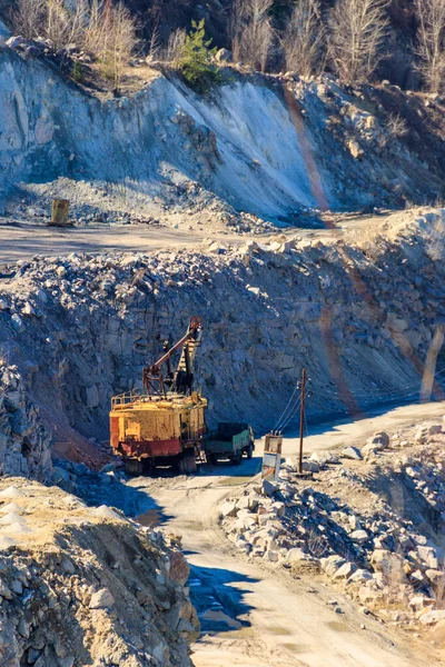 花崗岩の採石場で働く大きな黄色の掘削機 — ストック写真