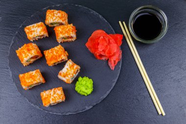 Suşi Philadelphia 'yı siyah bir levhada yuvarlıyor. Üst görünüm