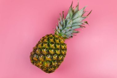 Pembe arka planda koca bir ananas. Üst görünüm