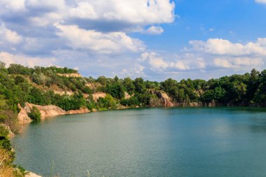 Yazın terk edilmiş taş ocağında göl manzarası