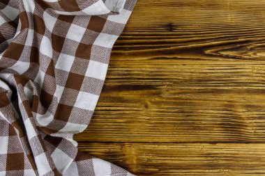Kahverengi, ahşap mutfak masasında katlanmış peçete. Üst görünüm, alanı kopyala