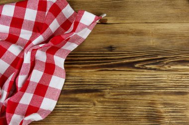 Kırsal ahşap mutfak masasında katlanmış kırmızı peçete. Üst görünüm, alanı kopyala