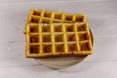 Beyaz ahşap masada Belçika waffleları. Üst görünüm