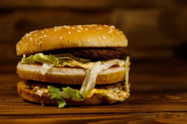 Ahşap masada lezzetli büyük hamburger.