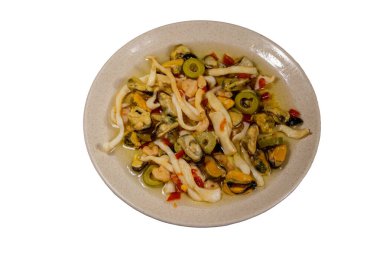 Beyaz arka planda karides, kalamar ve midye içeren deniz ürünleri salatası.