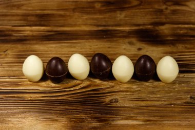 Tahta masada küçük çikolatalı şekerler. Ahşap arka planda çikolatalı paskalya yumurtaları
