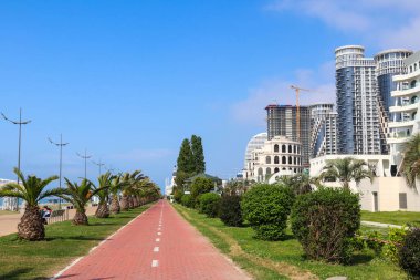 Gürcistan 'da palmiye ağaçları, bisiklet yolu ve modern mimariyle Batumi seti.