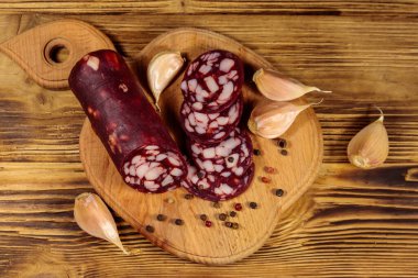 Tahta üzerinde dilimlenmiş salam sosisi. Üst görünüm