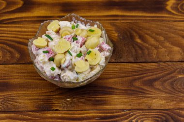 Ahşap masada marine mantar, sosis, soğan ve mayonez ile patates salatası