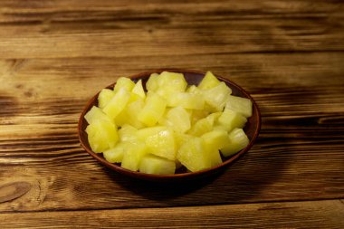 Ahşap masa üzerinde seramik tabakta konserve ananas parçaları