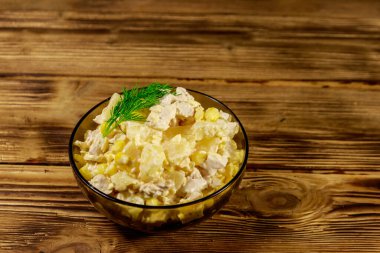 Tavuk göğsü, tatlı mısır, konserve ananas, peynir ve ahşap masada mayonez ile Şenlikli salata