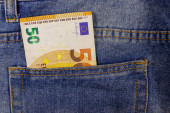 Padesát eurobankovek v kapse modrých džínů