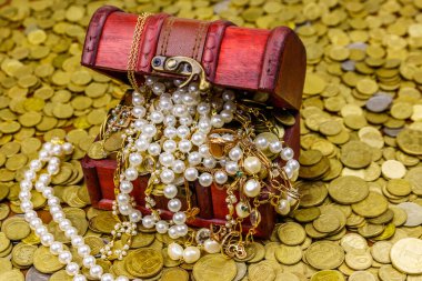 Altın sikke ve mücevherlerle dolu eski bir hazine sandığı.