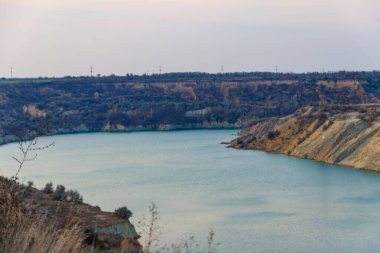 Sel basmış kum ocağında kumlu kıyıları olan bir göl manzarası