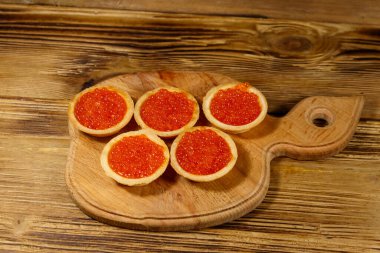 Tahta bir masada kırmızı havyarlı turta.