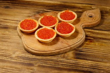 Tahta bir masada kırmızı havyarlı turta.