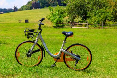 Kırsal bölgedeki yeşil çimlere park edilmiş modern bisiklet.
