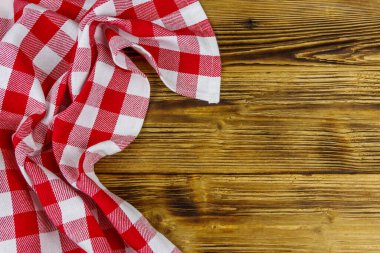 Kırsal ahşap mutfak masasında katlanmış kırmızı peçete. Üst görünüm, alanı kopyala