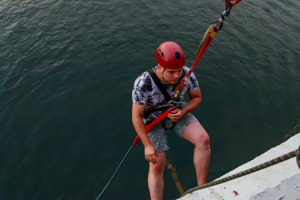 Rope jumping from high altitude of bridge. Bungee jumping from pedestrian bridge over beautiful river