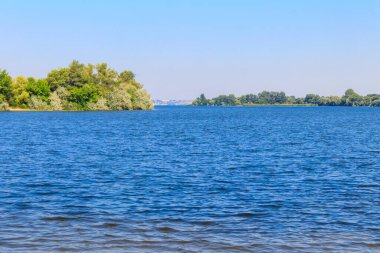 Güzel bir nehir, yeşil ağaçlar ve mavi gökyüzü olan yaz manzarası