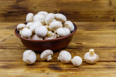 Tahta masada seramik kasede taze şampiyon mantarları.