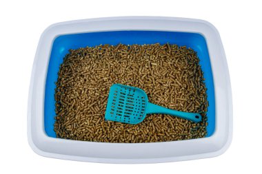 Beyaz arka planda kepçeyle doldurulmuş kedi kumluğu.