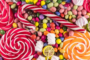 Renkli çikolata şekerlemeleri, lolipoplar, şeker kamışı ve şekerlemelerin arka planı